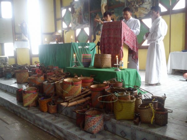 Cupai atau keranjang rotan warna-warni berisi benih, ditata rapi di depan altar, siap diberkati. (Foto: Marselina Evy).